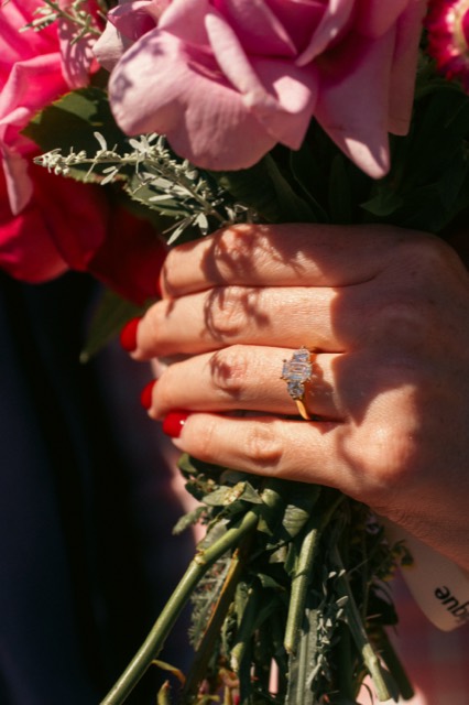 Close-up of an engagement ring over pink roses