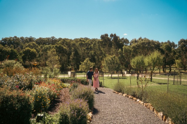 Couple walking a winding gravel path through botanic gardens